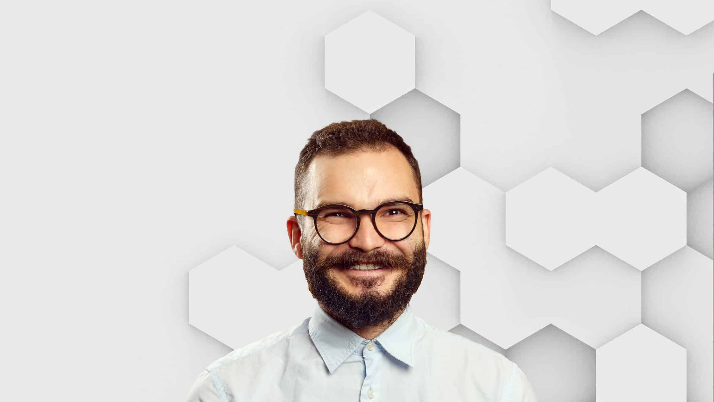 Ein Mann mit Bart und Brille lächelt.